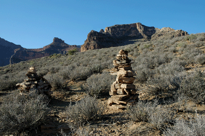 Cairns marking the western border of Cremation Creek Canyon with O'Neill Butte visible in the distance
