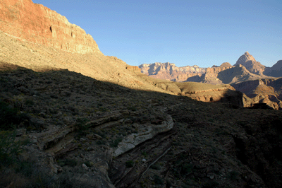 The Tonto trail hugs the edge of Hance Canyon with Vishnu Temple visible in the distance