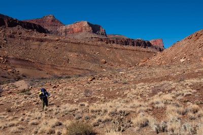 Hiking through a wide open valley in Basalt Canyon with Jupiter Temple off in the distance