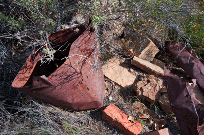 A rusted bucket and fireplace bricks