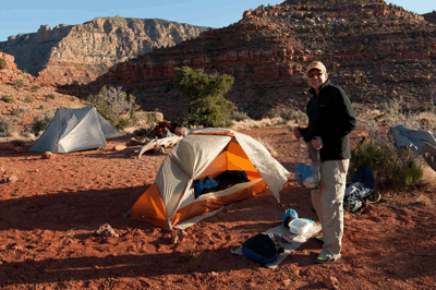 Dennis stands in front of his tent with Desert View Watchtower seen in the distance