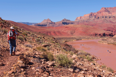 Hiking the Escalante Route with a Grand Canyon river trip floating by on the Colorado River